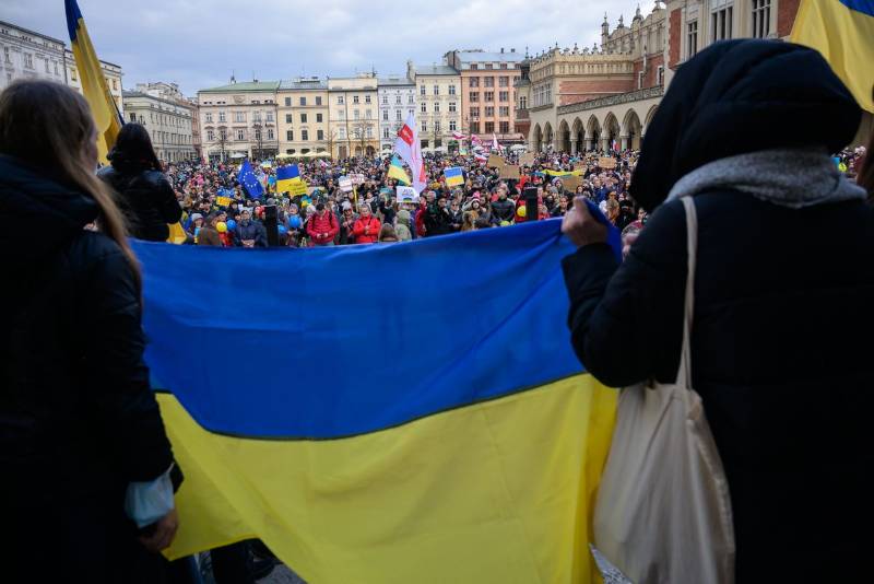 Люди с украинскими антивоенными плакатами участвуют в акции протеста против российского вторжения в Украину